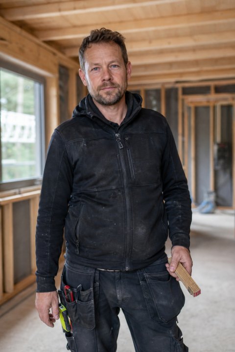 Representativ exempelbild av en snickare på en arbetsplats, halvbild i naturligt ljus.